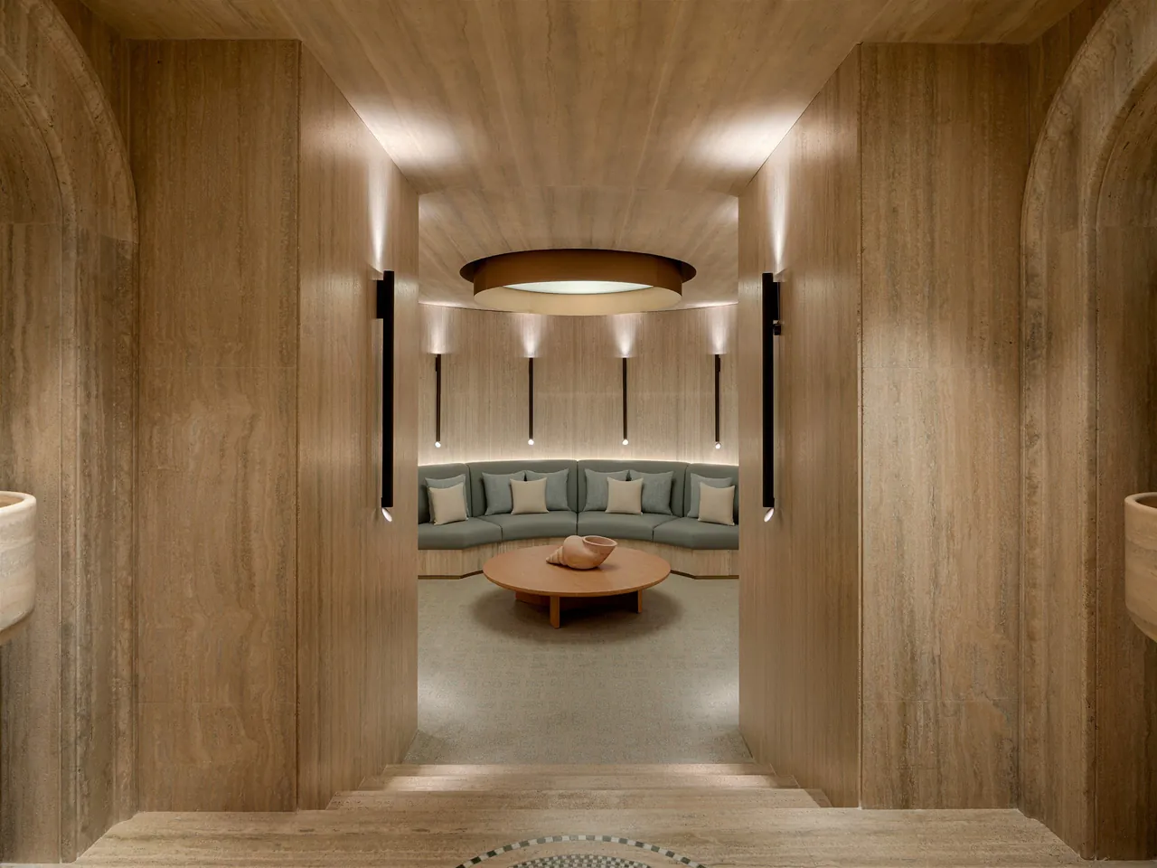 A travertine relaxation niche with a cushioned bench in the spa.