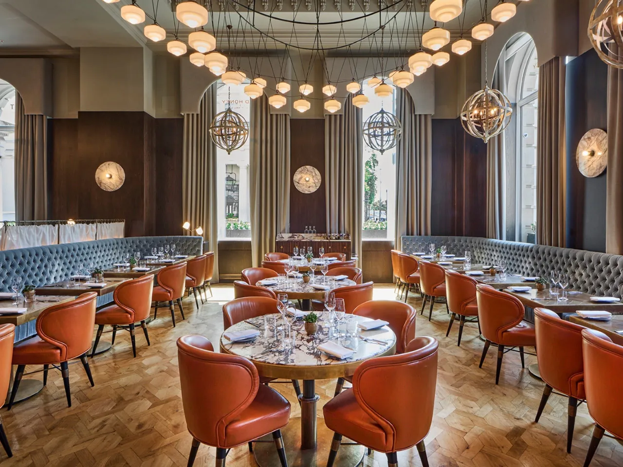 The restaurant with orange chairs beneath rows of globe lamps.