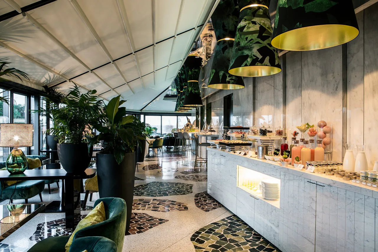 The breakfast buffet under the glass roof, set with pastries and fresh fruit.