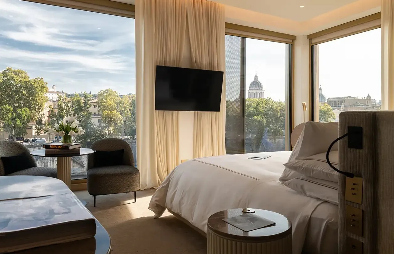 Studio with a large bed and windows looking out to a distant dome.