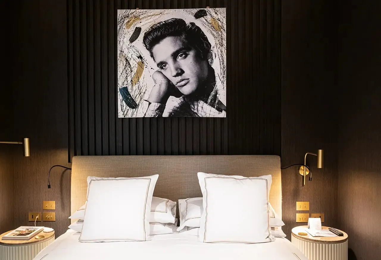 Suite bed beneath a large black and white portrait of Elvis.