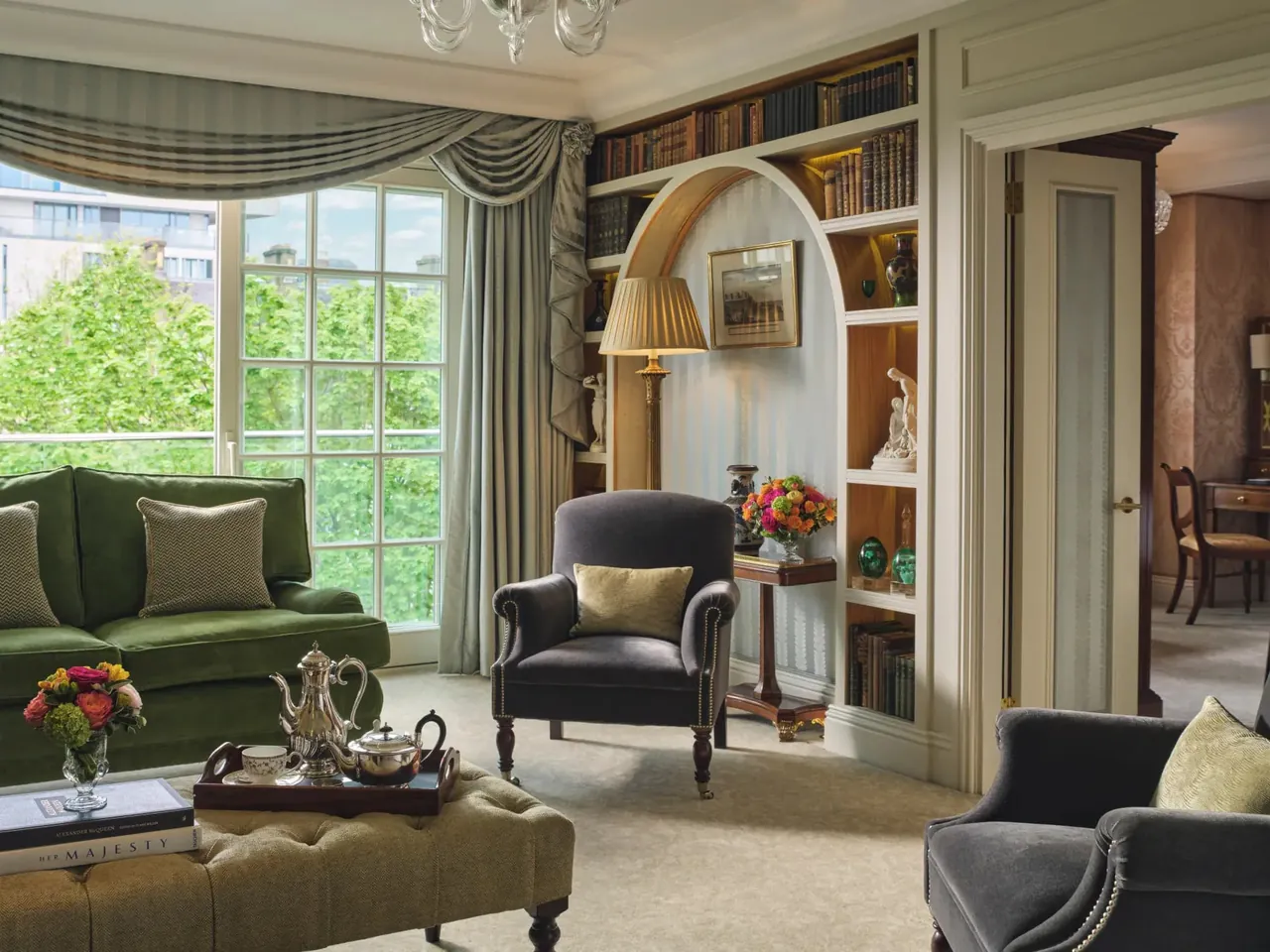 The sitting room of the Royal Suite with bookshelves and velvet chairs.