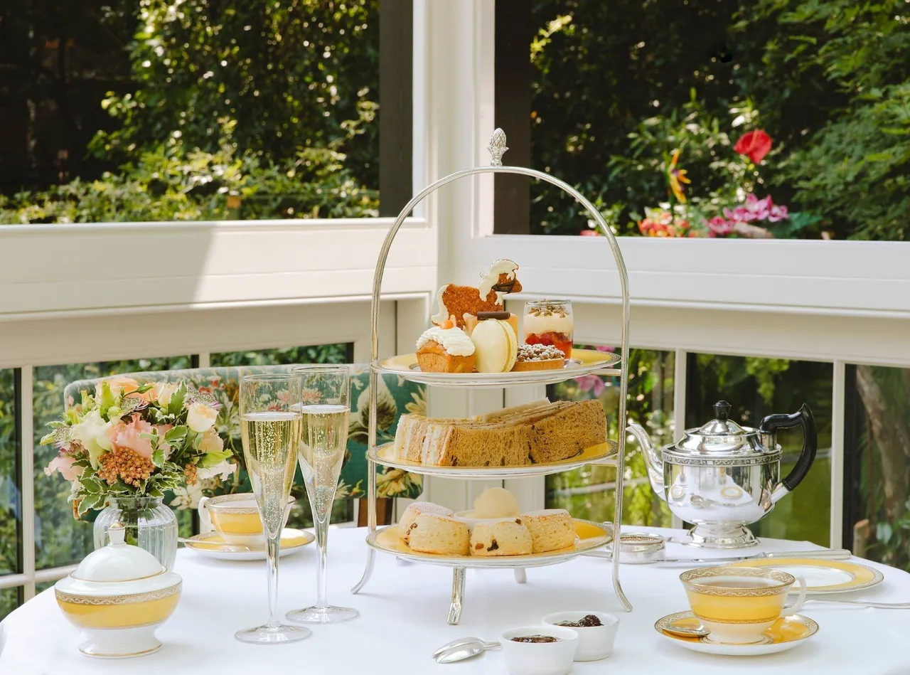 Afternoon tea on a tiered stand in the glass-walled garden lounge.