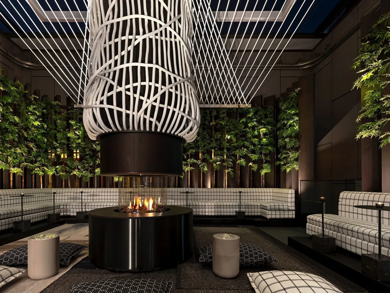 A fire pit surrounded by seating and green walls on the rooftop terrace.