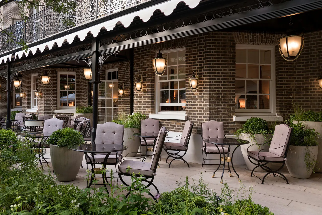Outdoor seating under a striped awning in The Secret Garden.